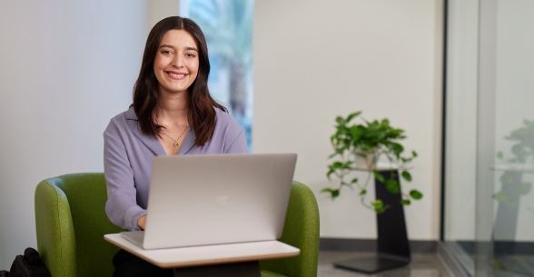 Thunderbird student Grecia Cubillas sits with her laptop at global headquarters