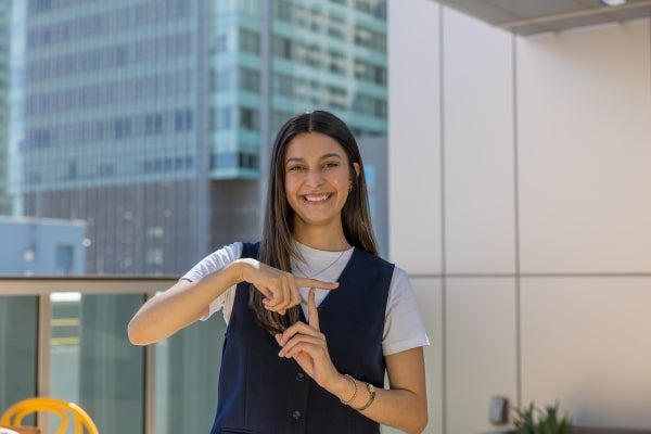 Image of a Thunderbird student at the Global Campus making a 'T' with her fingers.