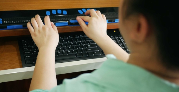 A student uses a braille keyboard.