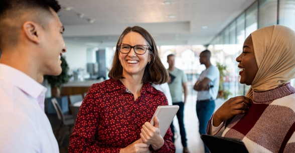 Three people talk at a networking event.