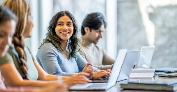 A graduate student studies with her peers.