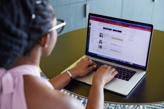 A Thunderbird students participates in an online learning course on her taptop