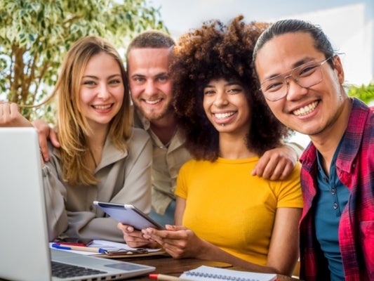 Image of four young adults smiling