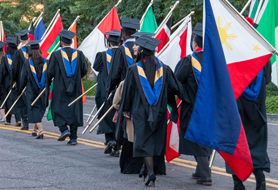 Image of Thunderbird graduates carrying their country's flags in the flag ceremony