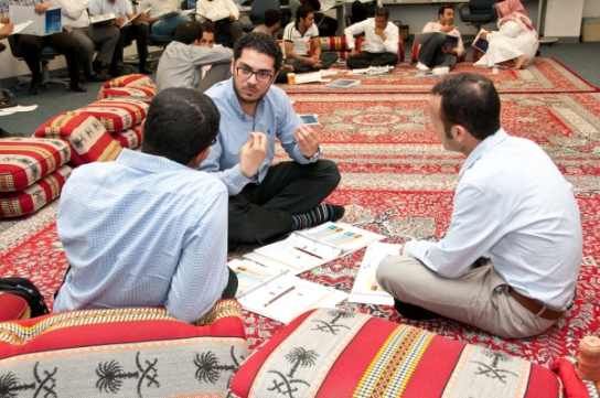 Image of businessmen sitting on a rug having a meeting